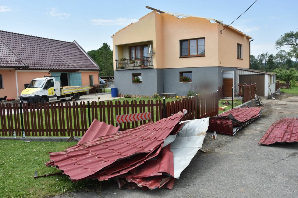 Downburst sebral střechu z domu (vpavo) a ta vletěla na stavení a hospodářské budovy sousedů (vlevo).