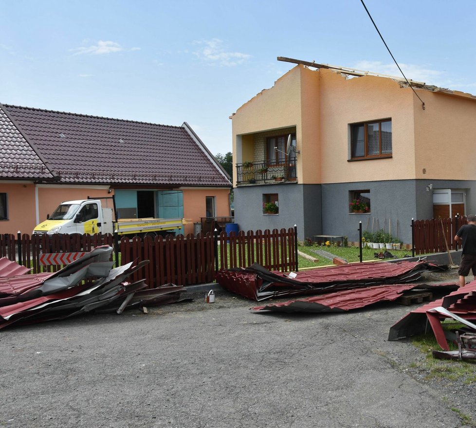 Downburst sebral střechu z domu (vpravo) a ta vletěla na stavení a hospodářské budovy sousedů (vlevo).