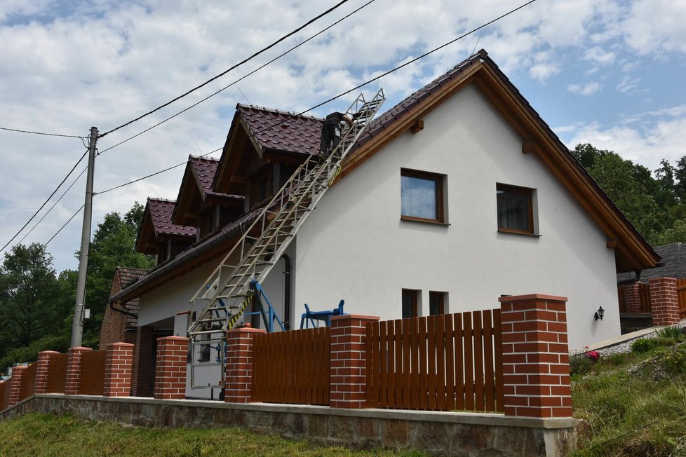 Letící střecha poničila střechu i na dalším domu, který stojí přes ulici.