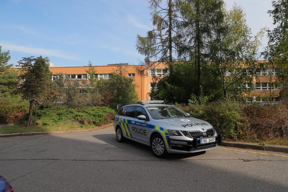 Okolo školy, kde volil prezident Miloš Zeman stálo několik policejních aut (2. 10. 2020)