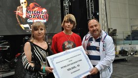 Michal David předává v Břeclavi šek na 100 tisíc korun Petrovi (15) a jeho mamince Oksaně. Peníze rodina vrátila.
