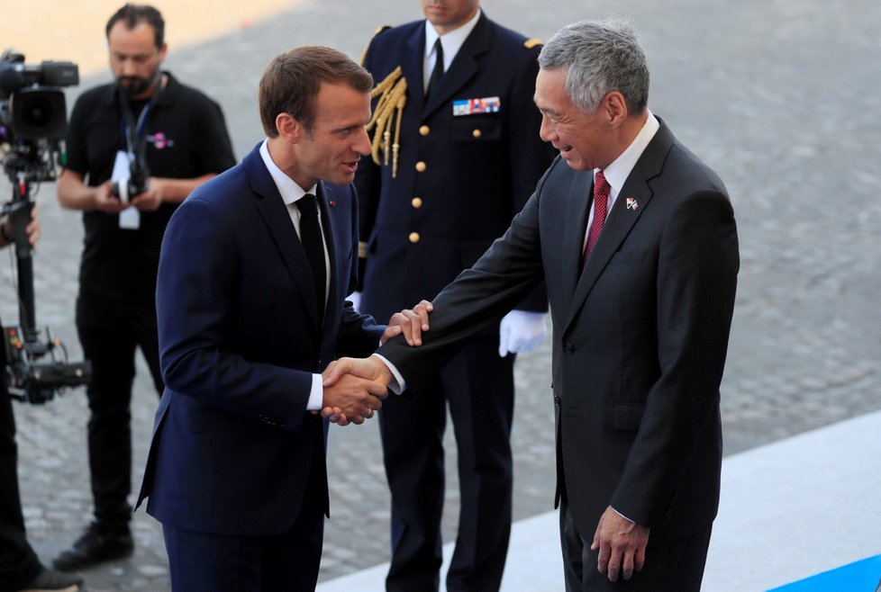 Prezident Macron vítá singapurského premiéra Lee Hsien Loonga na přehlídce při oslavách Dne Bastily v Paříži.