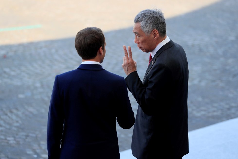 Prezident Francie Emmanuel Macron a premiér Singapuru Lee Hsien Loong na přehlídce v Paříži.