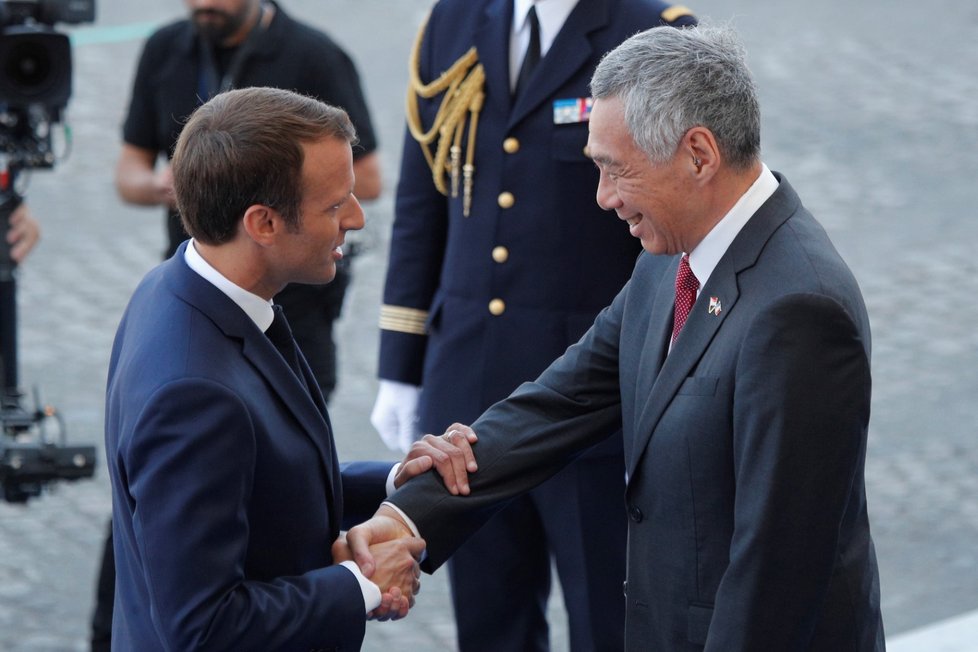 Prezident Macron vítá singapurského premiéra Lee Hsien Loonga na přehlídce při oslavách Dne Bastily v Paříži.