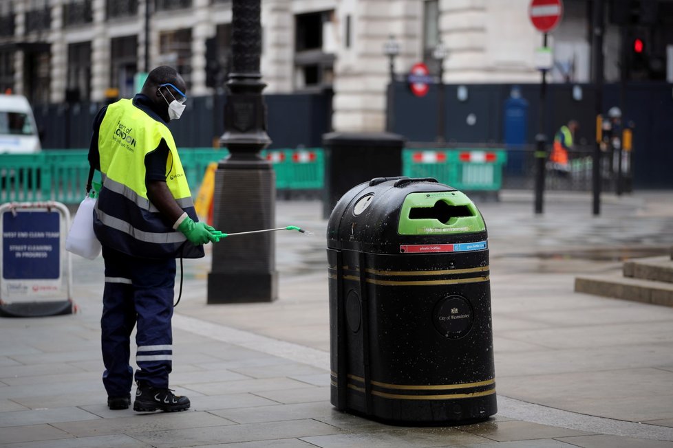 Pracovník dezinfikuje odpadkový koš v Británii.