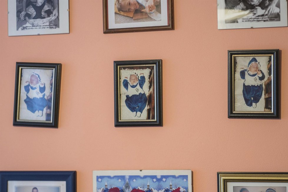 Na stěně obýváku visí zarámované fotky kluků dokumentující jejich dětství.