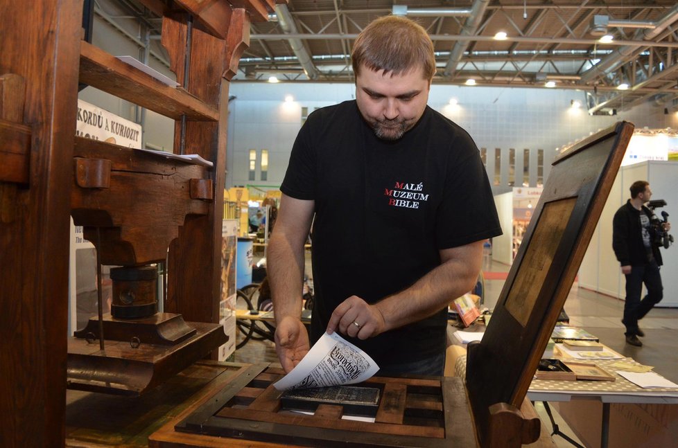 Vladislav Donát (38) z pelhřimovského Muzea Bible tiskne na replice středověkého tiskařského stavu stránku z Bible kralické.