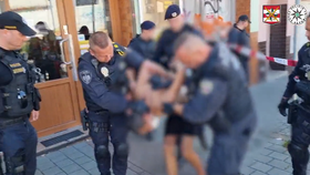 Policie odvádí muže, který pobodal dítě na ulici v Brně Židenicích.