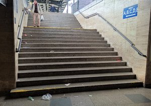 Schody vedoucí na 3. nástupiště brněnského hlavního nádraží. Jsou plné odpadků.