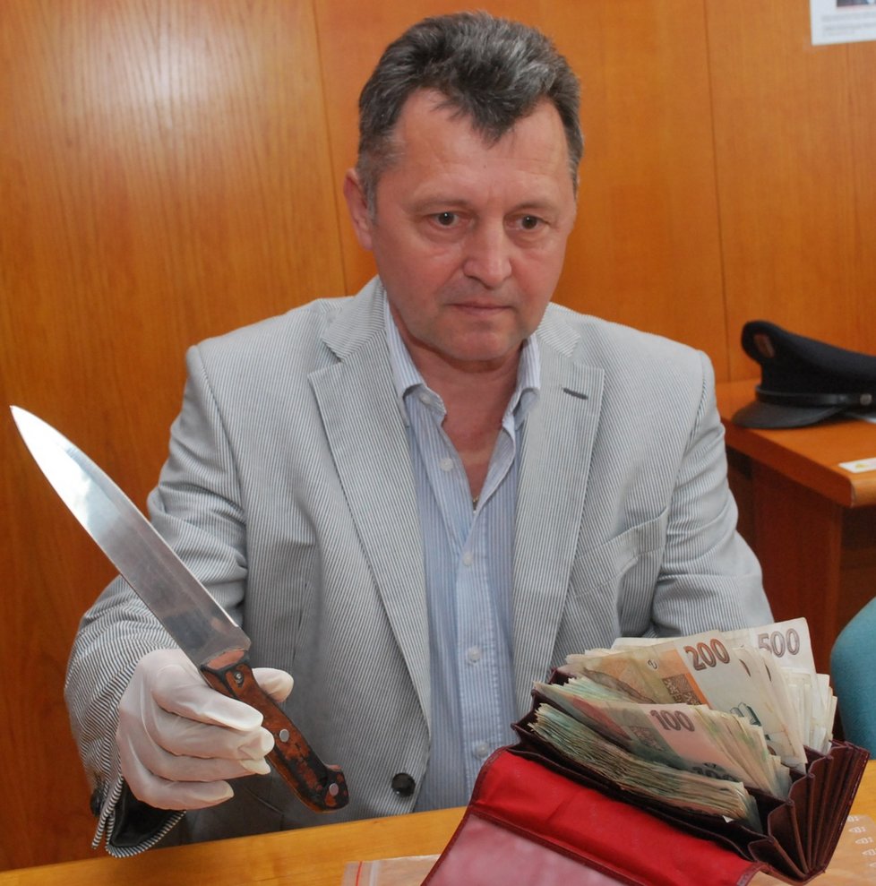 Kriminalista Miroslav Klusáček ukazuje lupičův nůž a flek s 45 tisíci korunami z posledního přepadení herny v centru Brna.
