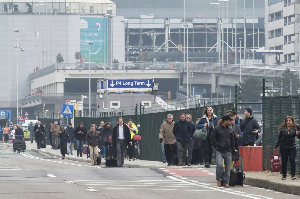 Lidé opouštějí letiště v Bruselu těsně po výbuchu.