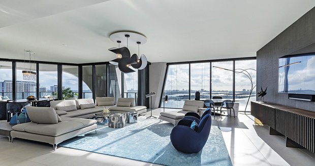 Byt je zařízený ve světlých tónech v&nbsp;kombinaci s&nbsp;modrou. Designový lustr je od slavného německého návrháře Uliho Petzolda.