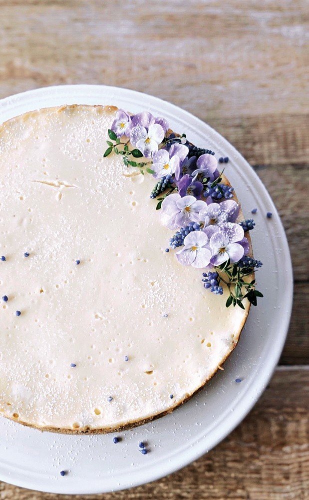 Neodolatelný jarní tvarohový cheesecake je zdobený květinami a bylinkami ze zahrady.