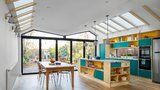 Pestrobarevný dům pro rodinu zdobí střecha ve tvaru motýla porostlá zelení