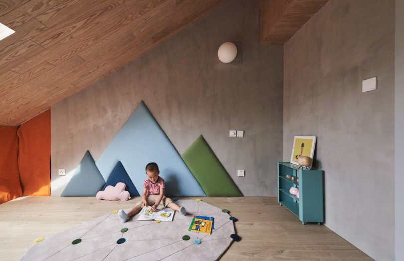 Moderní dům s šikmými stěnami nabízí originální bydlení pro malé dítě i rodiče, kteří pracují z domova