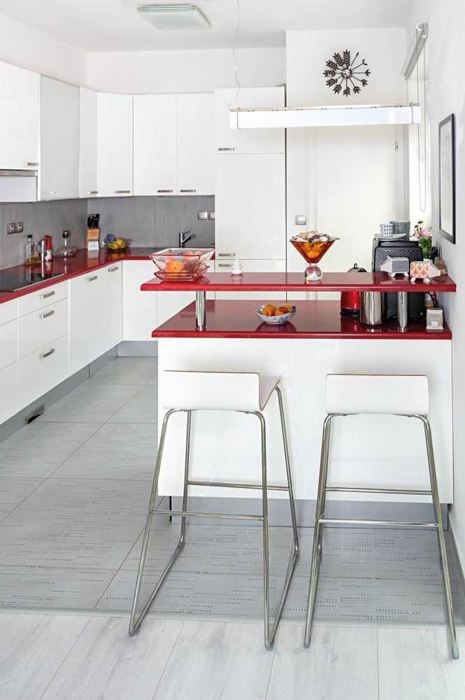 Hlavní obytný prostor s kuchyní je oživen dotykem červené barvy.