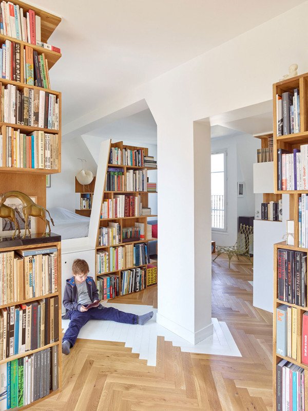 Podkrovní byt s vestavnými knihovnami, které vytváří pozoruhodné prostředí k životu