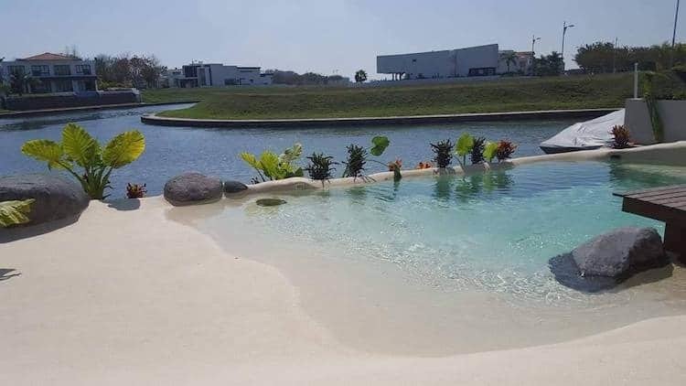 Písečná pláž kolem bazénů vypadá skoro jako skutečná