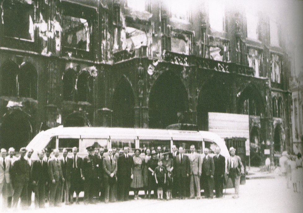 Během první poválečné okružní jízdy 6. 6. 1945 pózovali účastníci před vypálenou Staroměstskou radnicí.