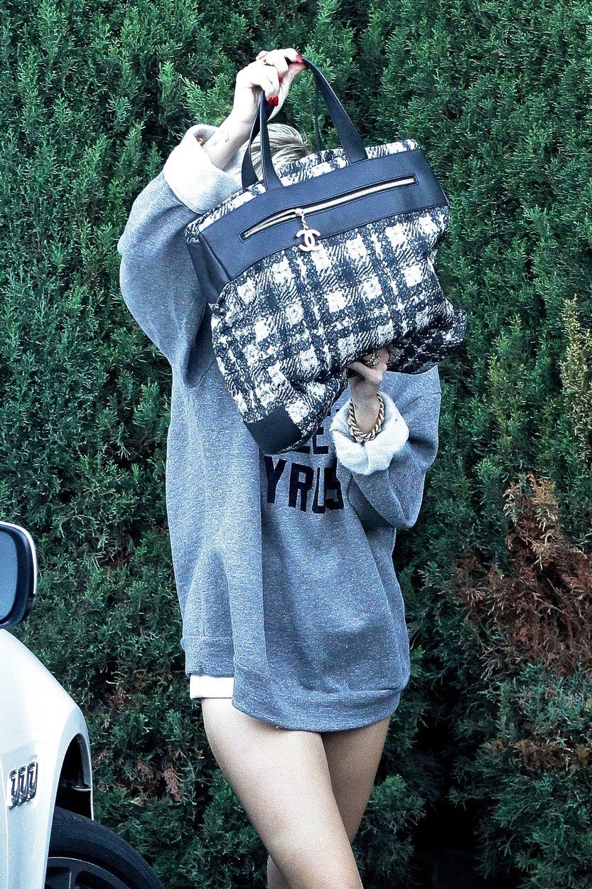 Maskované celebrity: Miley Cyrus se schovávala za taškou.