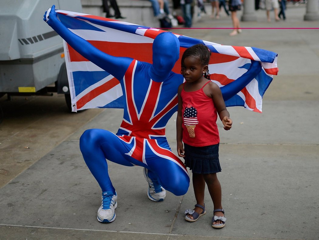 Muž oblečený do modré kombinézy se u Trafalgar Square fotí s malou holčičkou.