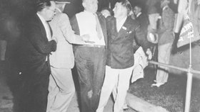 Zraněný Cermak je odváděn z místa atentátu na prezidenta.