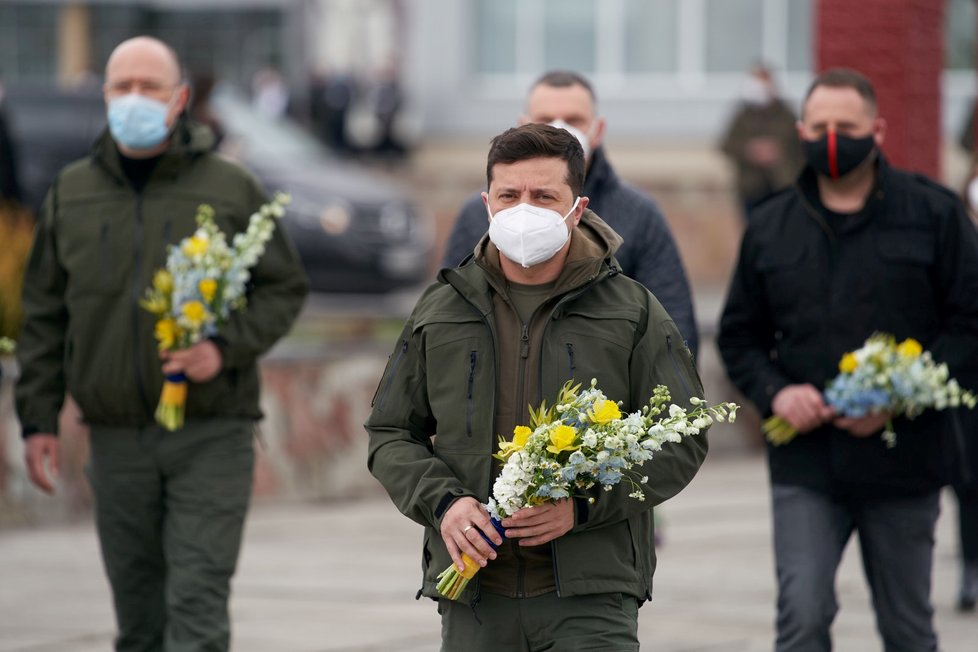 Ukrajinský prezident Volodymyr Zelenskyj nese květiny k pomníku černobylských hrdinů.
