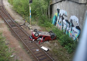 Následky ošklivé dopravní nehody v Černokostelecké ulici. Žena prorazila svodidla a se svým vozem spadla z mostu přímo do kolejiště. (3. 8. 2023)