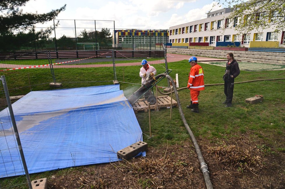Dělníci zalili díru po propadu půdy u základní školy na Černém Mostě.