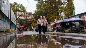 Ženy procházejí místním tržištěm pod protidronovými sítěmi nataženými nad ulicí během lokálního příměří spojeného s humanitární misí v Oleškách v Chersonské oblasti na Ukrajině (29. 10. 2026)