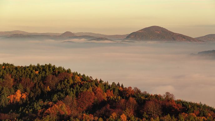 Podzimní svítání a rána jsou na Kokořínsku nejkrásnější. Do batohu si přibalte termosku s kafem nebo čajem a kochejte se výhledy do mlhavé krajiny plné barev a zlatého slunce.