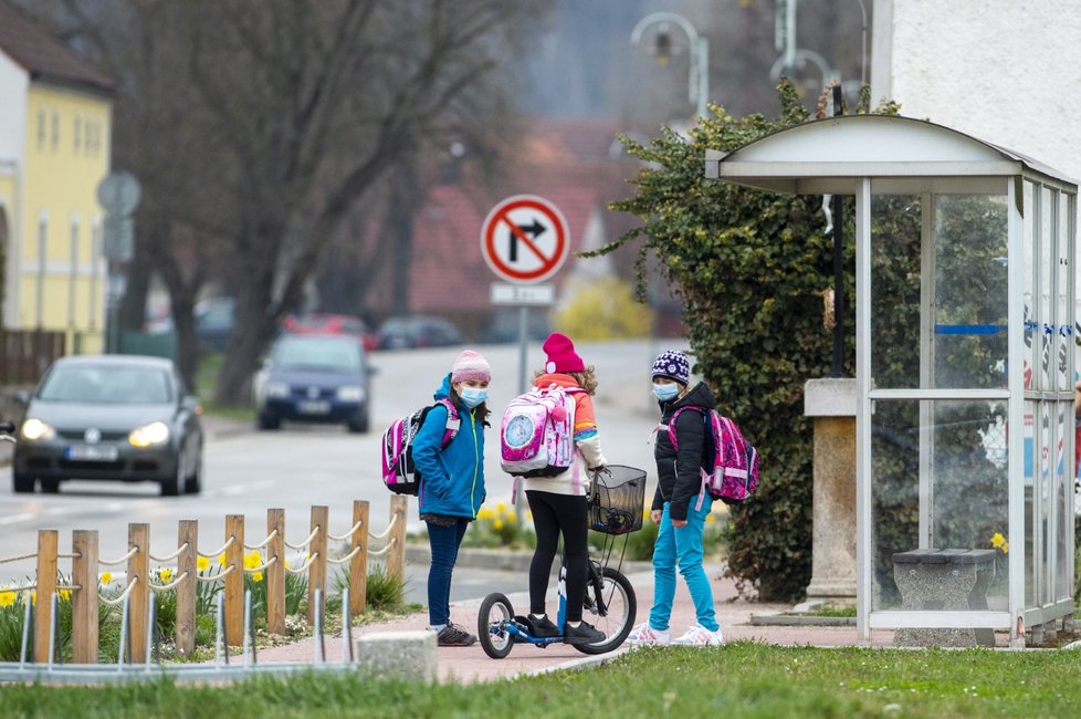 Některé spoje autobusové dopravy v Jihočeském kraji, které byly kvůli omezení souvisejícím s koronavirem dočasně zrušeny, byly obnoveny. Na snímku čekají školáci na spoj na zastávce před školou v Hrdějovicích u Českých Budějovic (12. 4. 2021).