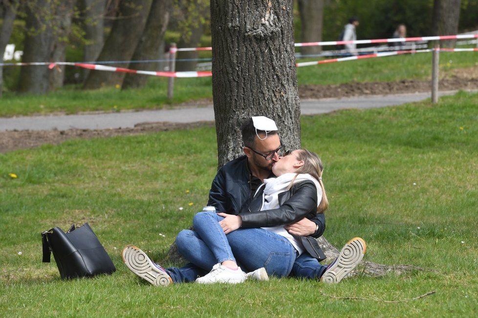 Dvojice při polibku pod stromem na Petříně v Praze, kde Iniciativa Chcípl PES uspořádala akci s prvomájovou procházkou na protest proti přístupu vlády k řešení pandemie (1. 5. 2021)
