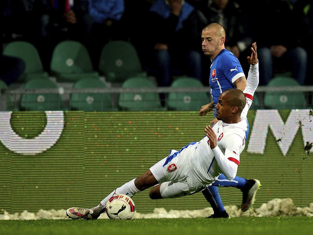 Pravý obránce Česka Theodor Gebre Selassie v souboji se slovenským soupeřem