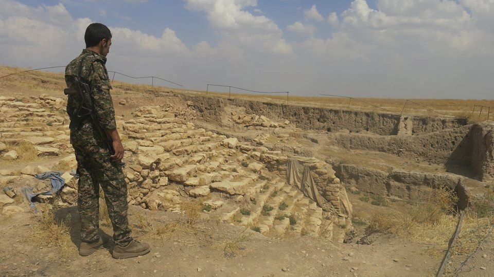 Kurdský voják hlídkuje u archeologického naleziště. Barbaři z Islámského státu historické památky naopak ničí