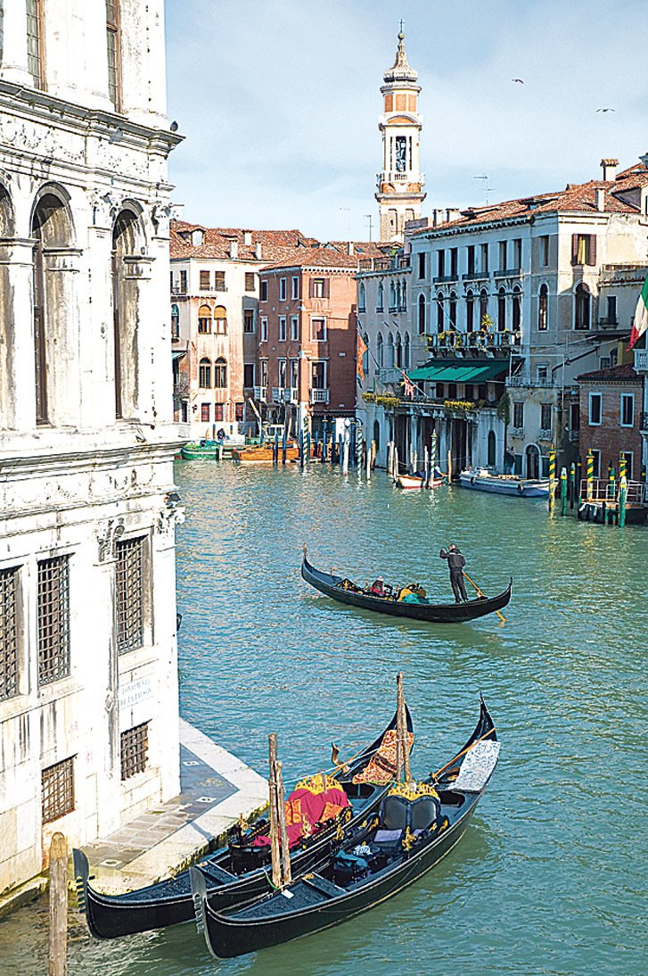 Město protkané kanály s gondolami – to jsou Benátky.