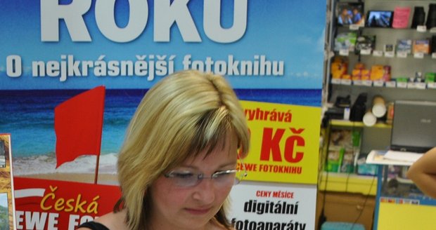 Výherkyně soutěže Lenka si prohlíží svou knihu fotografií, kterou si sama vytvořila.