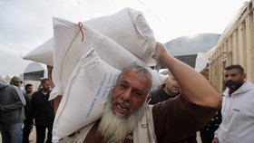 Lidé v Chán Júnisu na jihu Pásma Gazy dostávají potravinovou pomoc (27. 11. 2023).