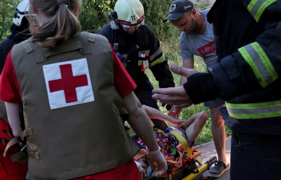 Záchranáři se starají o zraněné po útoku v Charkově (27.6.2022)