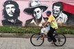Muž z Nicaraguy veze na kole svého syna kolem věže Diriomo, na níž jsou vyobrazeny různé postavy z historie země