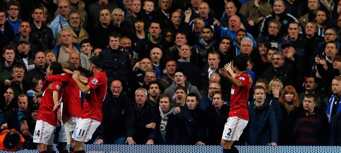 Oslava fotbalistů Manchesteru United a vlevo dole zraněný steward, vpravo zase leží kus modré sedačky.