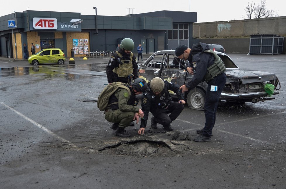 Vyšetřovatelé v Chersonu zkoumají škody po dopadu ruské rakety k supermarketu. (11. 3. 2023)