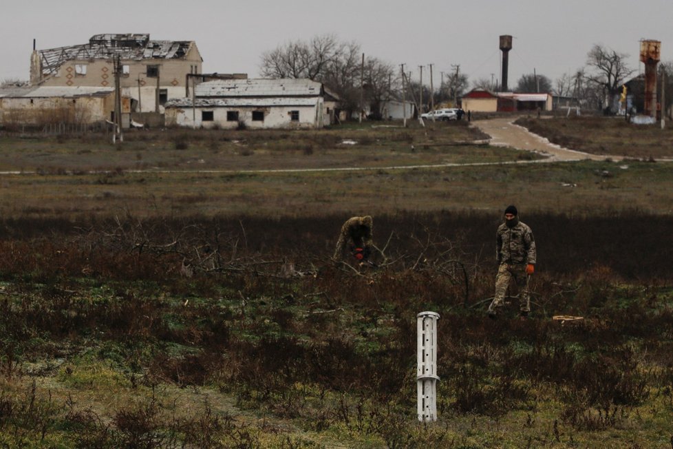 Ukrajinští vojáci u použitého kazetového granátu MLRS v obci Nová Zoria v Chersonské oblasti.
