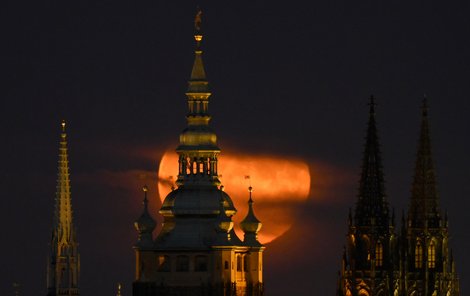 Měsíc se vyhoupl z mraků nad památníkem na pražském Vítkově.