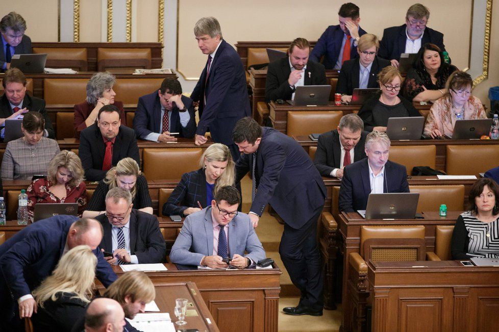 Jan Chvojka (ČSSD, šedé sako uprostřed) a Pavel Kováčik (KSČM) jsou ve sněmovní lavici sousedé