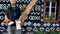 Čičmanský podnikatel Juraj Kudjak před malovanou dřevěnicí, se svými výrobky v rukou