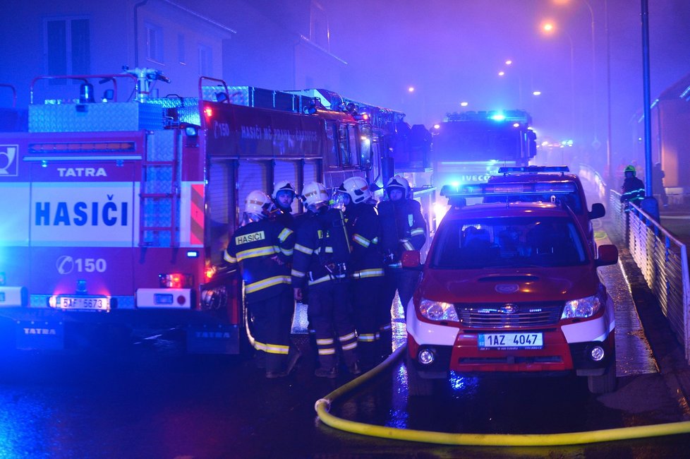 V Čimické ulici hořely přístřešky vedle autodílny, ve kterých byly uložené propanbutanové lahve. Plameny navíc přeskočily na vedlejší domy.