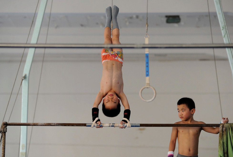 Malé děti v čínských gymnastických školách tvrdě dřou už od útlého dětsví.