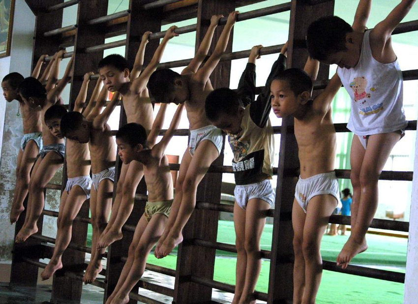 Děti s utrpením ve tváři. Běžný obraz z čínských gymnastických škol.