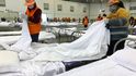 Pracovníci připravují postele v kongresovém centru, které bylo přeměněno na dočasnou nemocnici ve Wu-chanu v provincii Hubei ve střední Číně. Čína uvedla, že v úterý počet infekcí způsobených novým virem překonal 20 000.